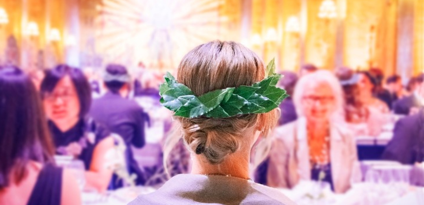  Woman seen from behind at banquet, wearing a bearing wreath. 