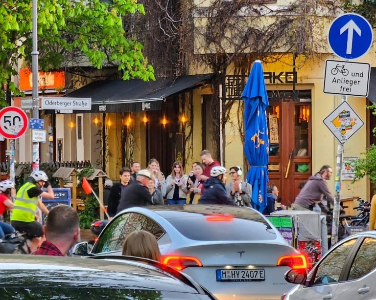 Bilar som väntar på att cyklar ska åka över en gata.
