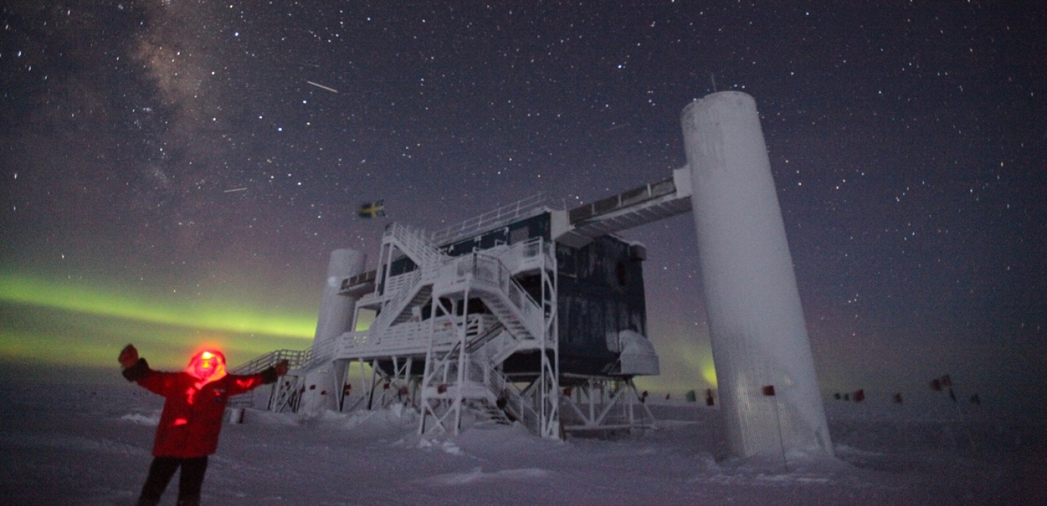 Vinterklädd forskare framför neutrinoteleskopet IceCube 