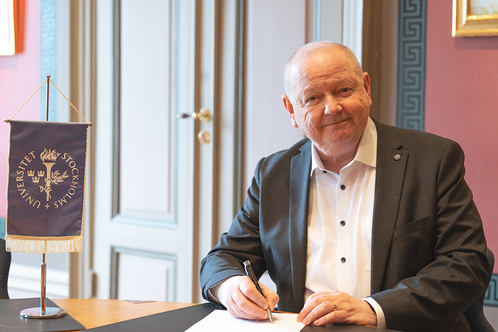 University President Hans Adolfsson signs the memorandum of understanding.