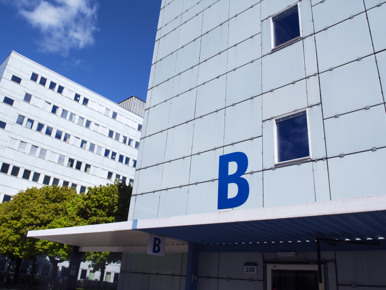 A tall building with a blue b on the side of it.