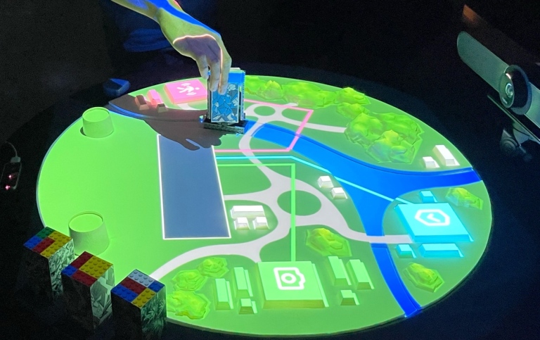 The project’s prototype is shown as a tabletop interactive display composed of 3D printed objects.