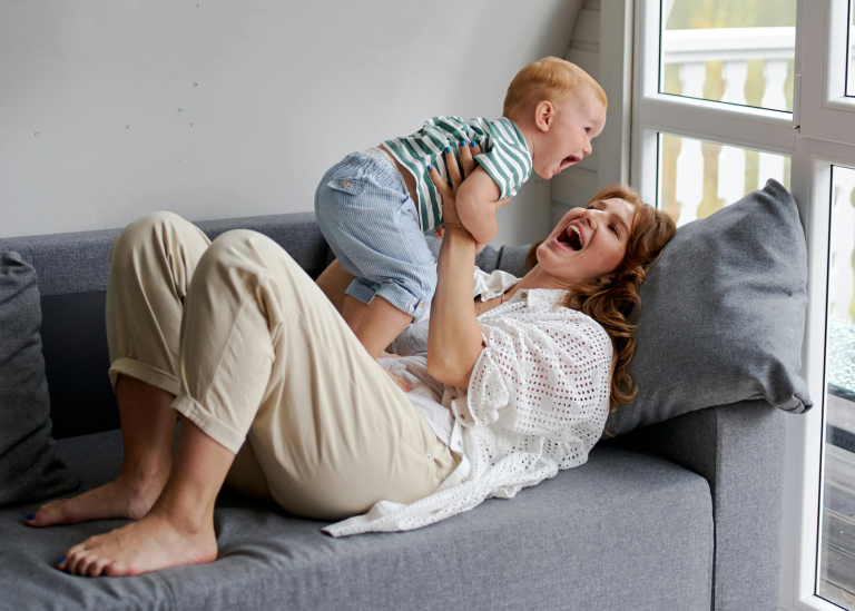 Mamma och bebis kommunicerar i en soffa.