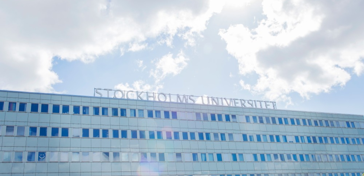 Bild på en av de ljusblåa byggnaderna vid Stockholms universitet.