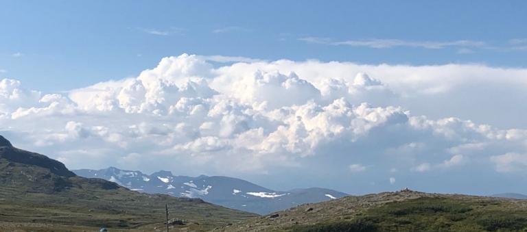 Blue sky, white clouds and green mountains.
