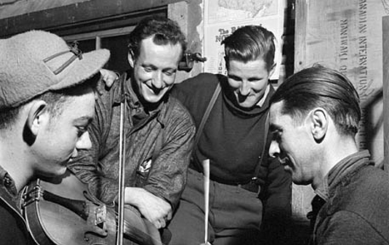 French-Canadian lumberjacks playing the fiddle with sticks for percussion, in a lumber camp in 1943.