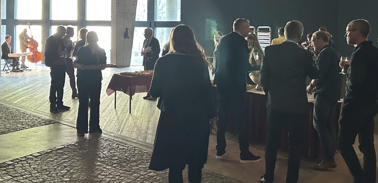 Personer minglar framför ett liveband.