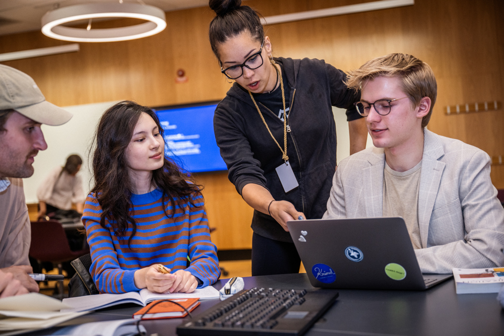 Studenter och en lärare diskuterar på en lektion.