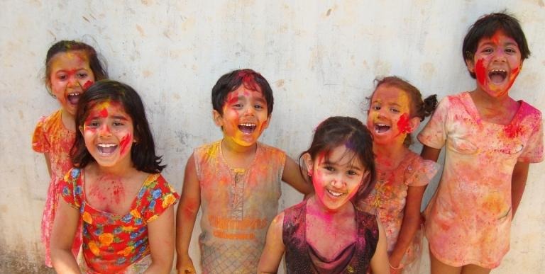 Children covered in paint during religious festival