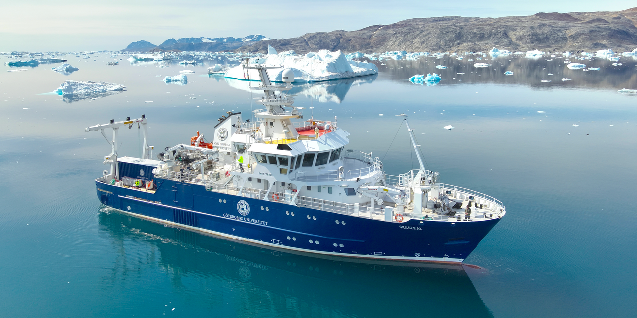 RV Skagerak at sea, with Greenland’s coastline and small icebergs visible in the background.