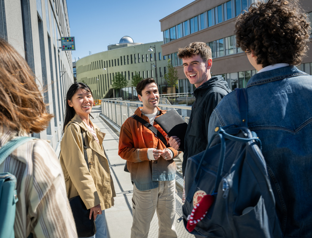 A group of people standing around talking to each other.