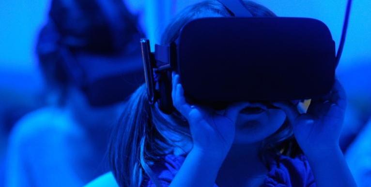 Young girl tries a virtual reality (VR) headset.
