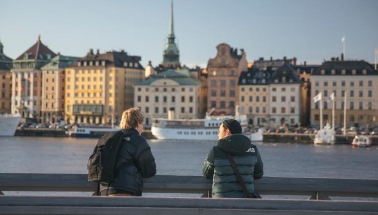 Studenter stående vid en bro, blickar ut över Stockholm