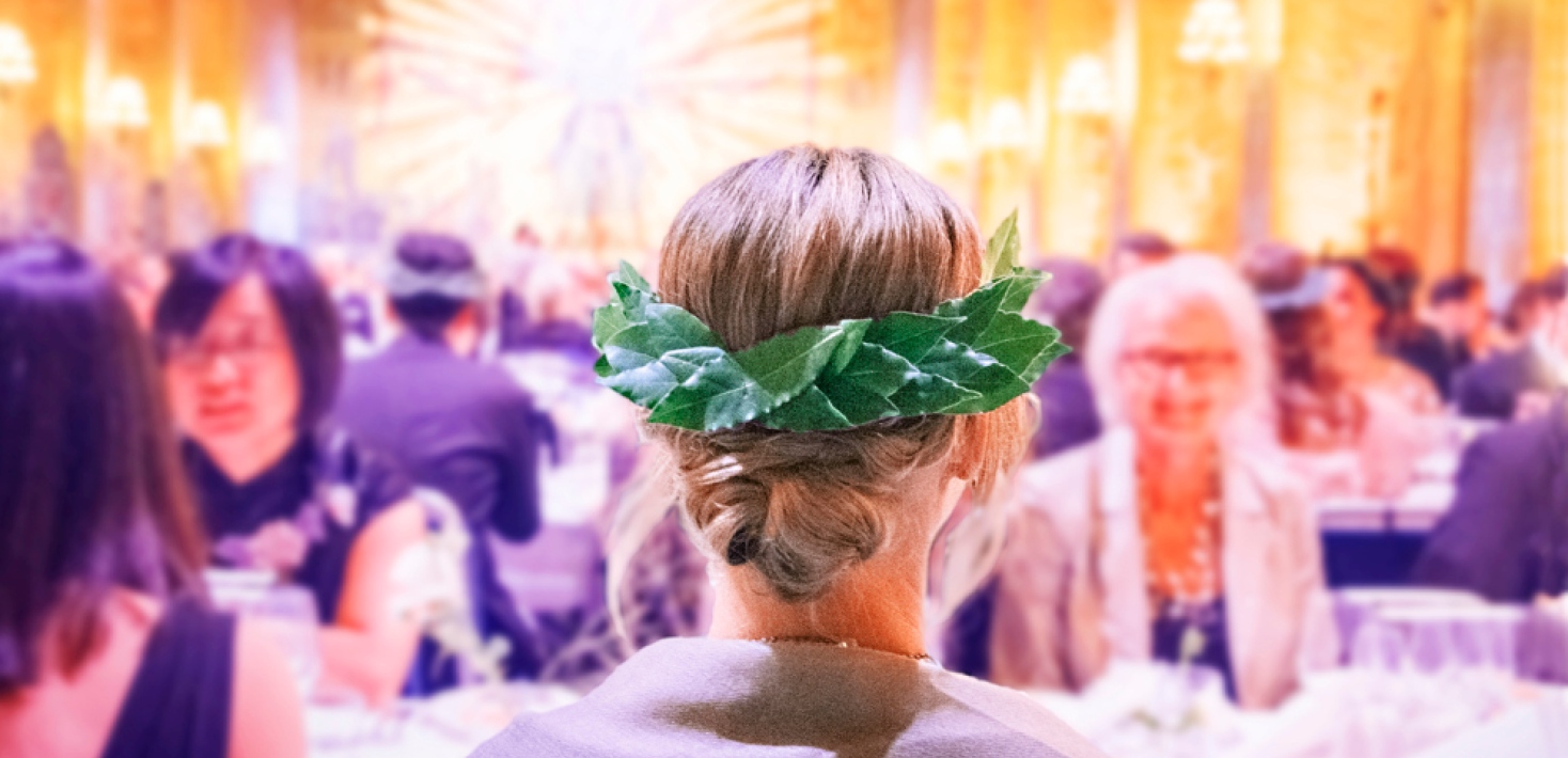 Nybliven doktor i med lagerkrans i håret, sedd bakifrån.