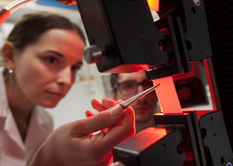 Two researchers closely looking at an object.