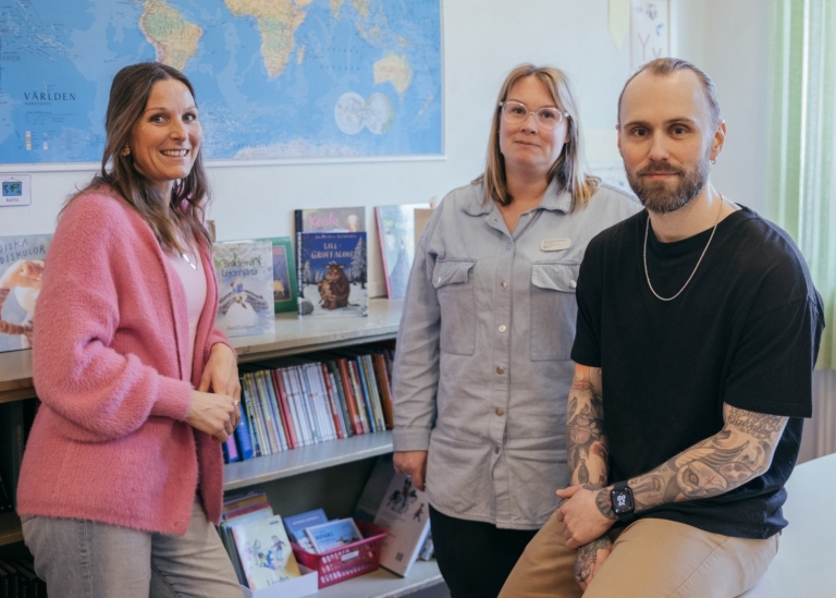 Eva, Lukas och Rebecka står i ett klassrum tillsammans.