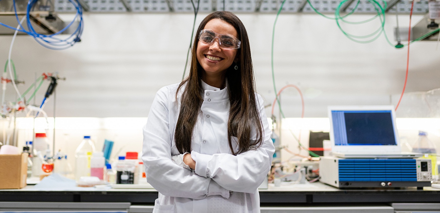 Content young woman, armes crossed, in front of a lab