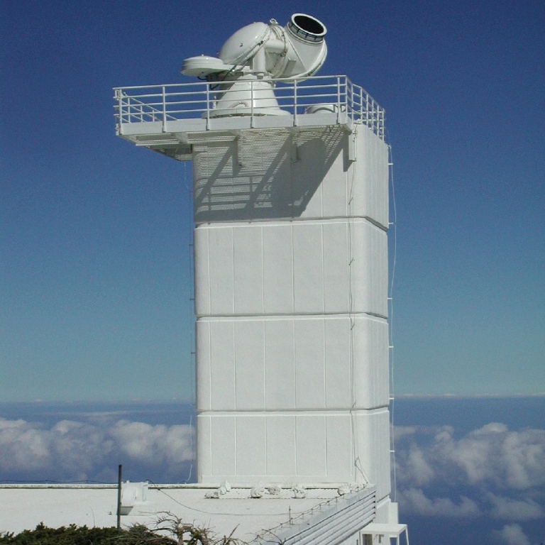 A white tower with clouds in the background