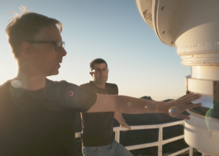 Two people next to the lens of the solar telescope