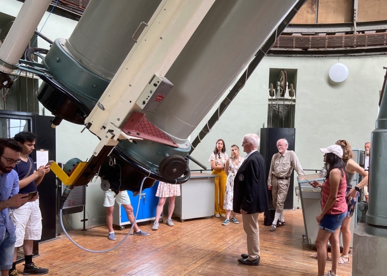Astronomersgathered around the refractor telescope