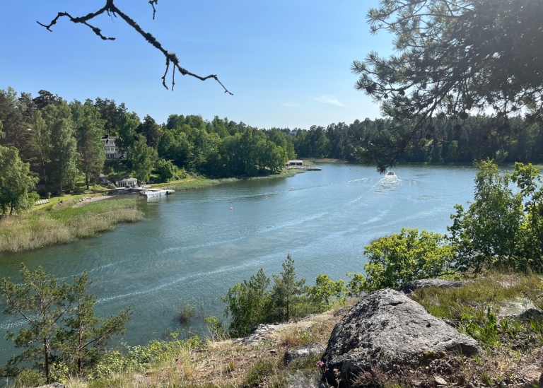 Snabb båt passerar skärgård.