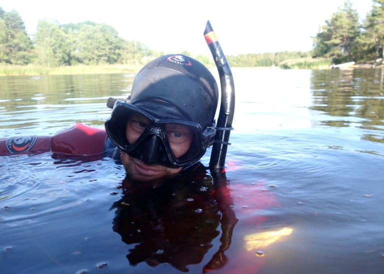 Forskare snorklar i grumlig Östersjövik.