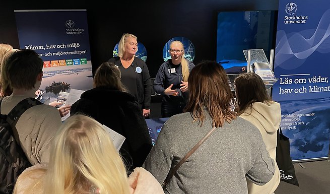 två kommunikatörer pratar inför en grupp studenter om utbildningar på stockholms universitet
