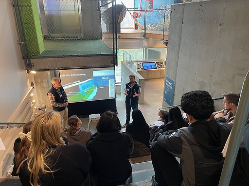 två forskare pratar inför en grupp studenter om forskning inommarin geovetenskap