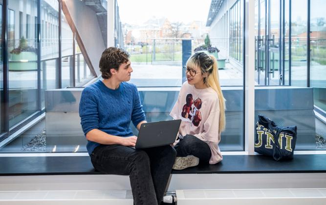 Studenter på Campus Albano som sitter och pratar med varandra.