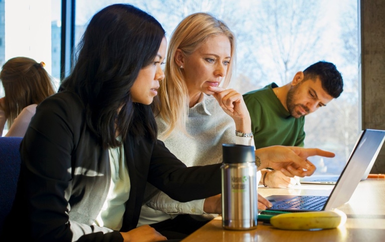 Kvinnliga studenter som sitter och diskuterar vid laptop. Foto: Jens Olof Lasthein