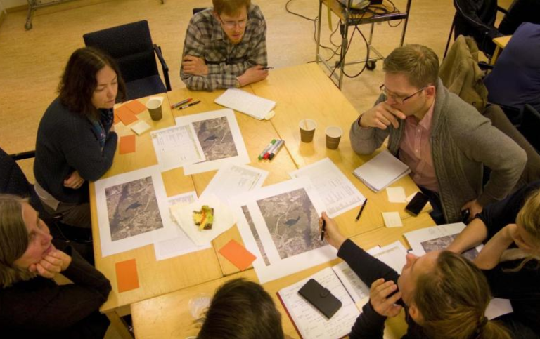 People discussing and working at a round table