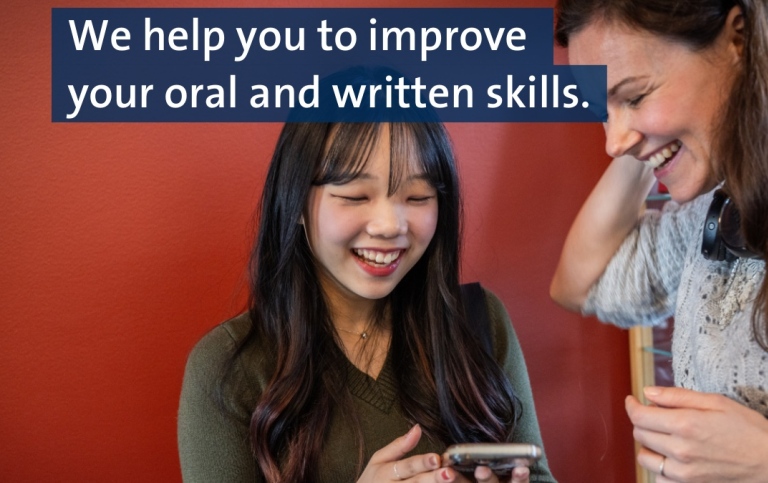 Two students happily looking at cellphone. Text: We help you to improve your written and oral skills.