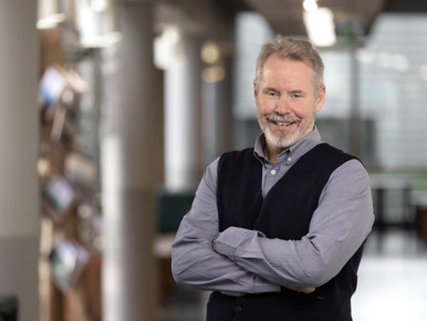A man standing in a building with his arms crossed.