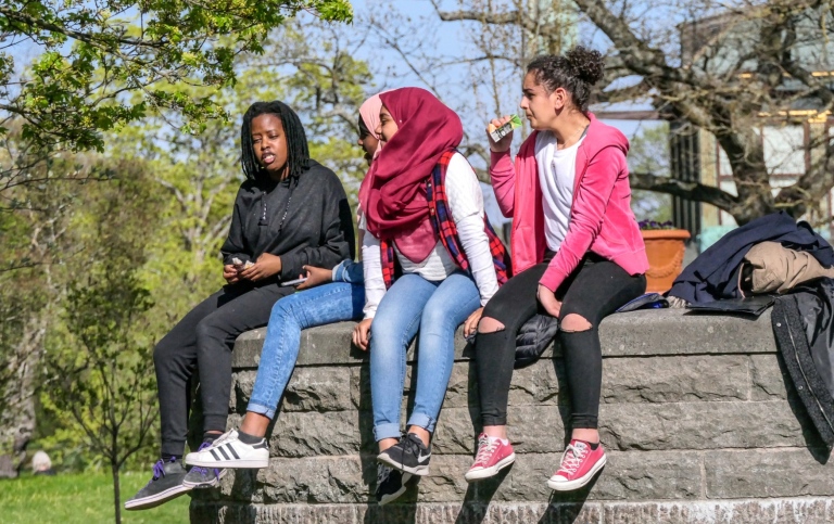 Multiethnic teenagers sitting outside.