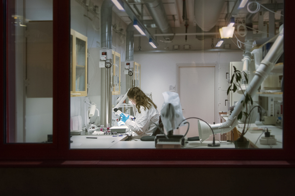 A woman sitting at a microscope