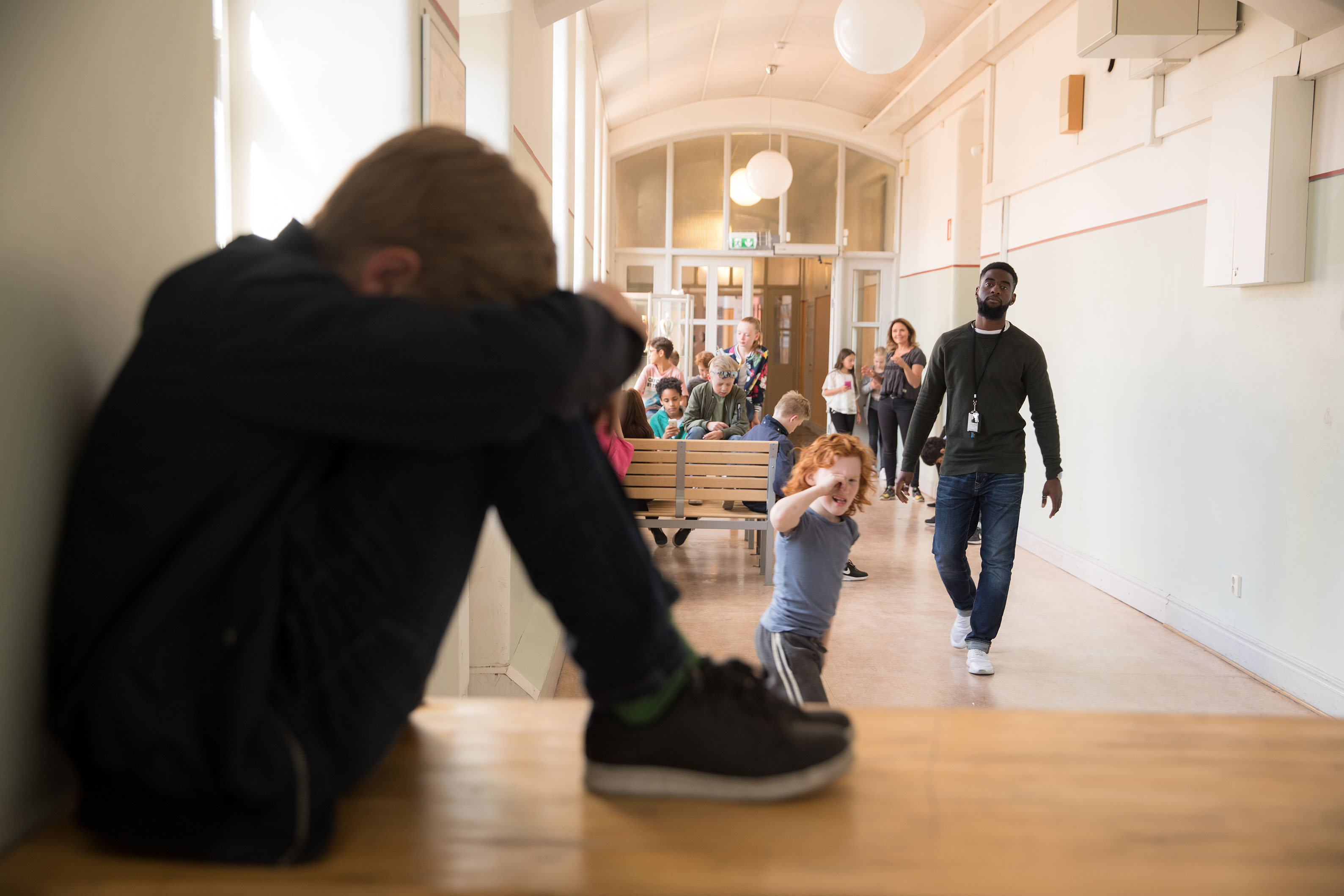 Mellanstadielever springer genom skolkorridor.