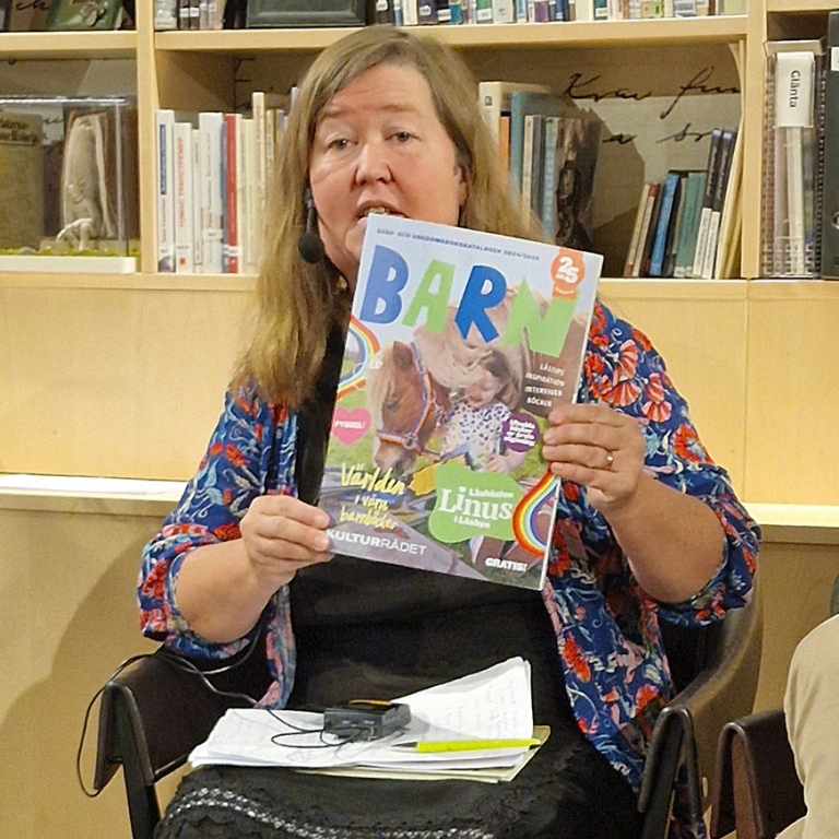 Anna Hällgren håller upp boktidningen BARN.