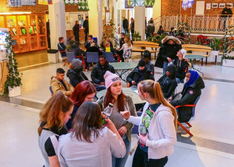 Interiörbild gymnasium med grupper av elever