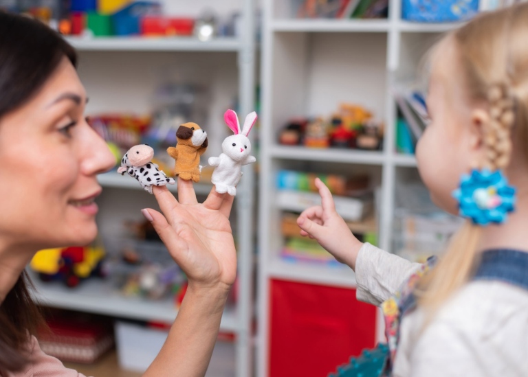 Female speech therapist and a little girl. Photo by Mostphotos
