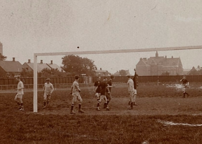 Svartvitt foto. Personer spelar fotboll.