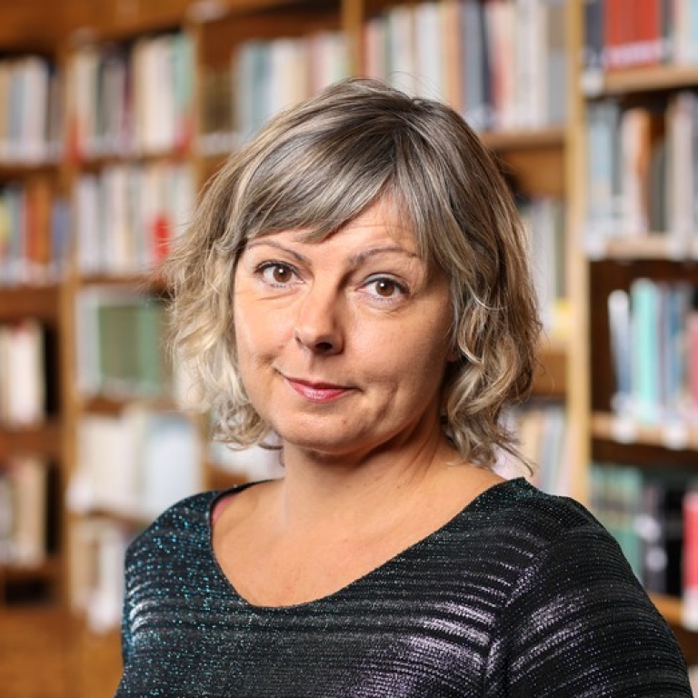 Tanja Schult framför en vägg med bokhyllor.