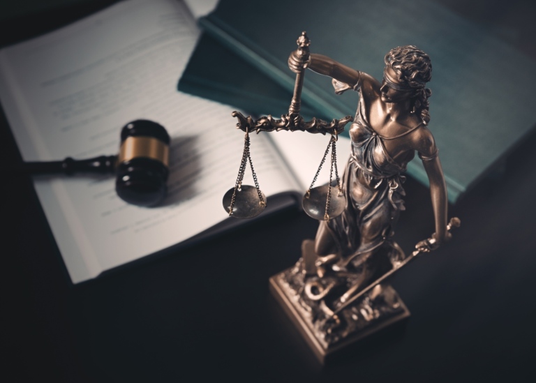 Fru justitia staty med lagböcker i bakgrunden