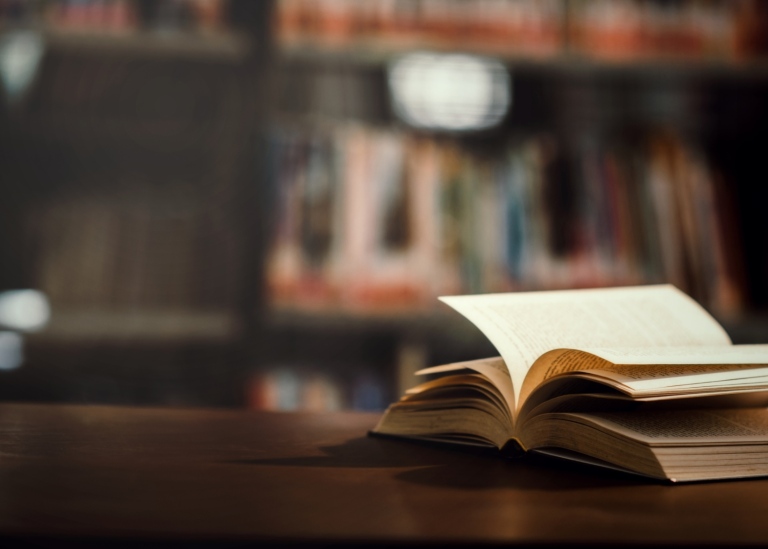 Öppen bok på bord i ett bibliotek