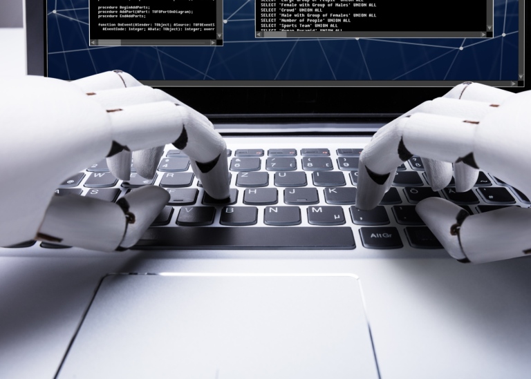 närbild på robothänder som skriver på en laptop