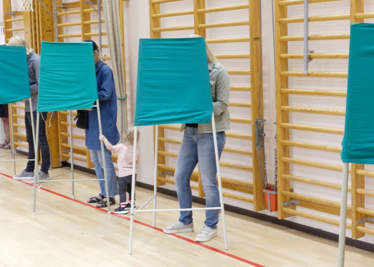 Folk röstar i röstningsbås