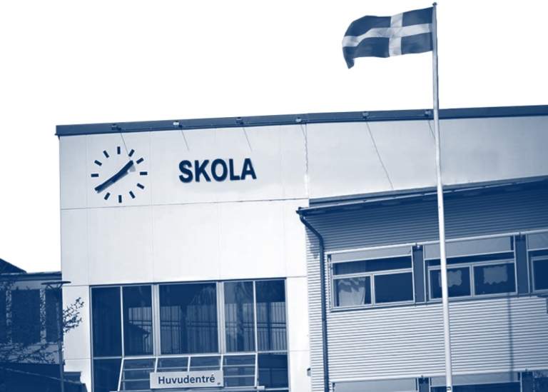 Del av omslaget till avhandlingen där fasaden på en skola syns och en svensk flagga