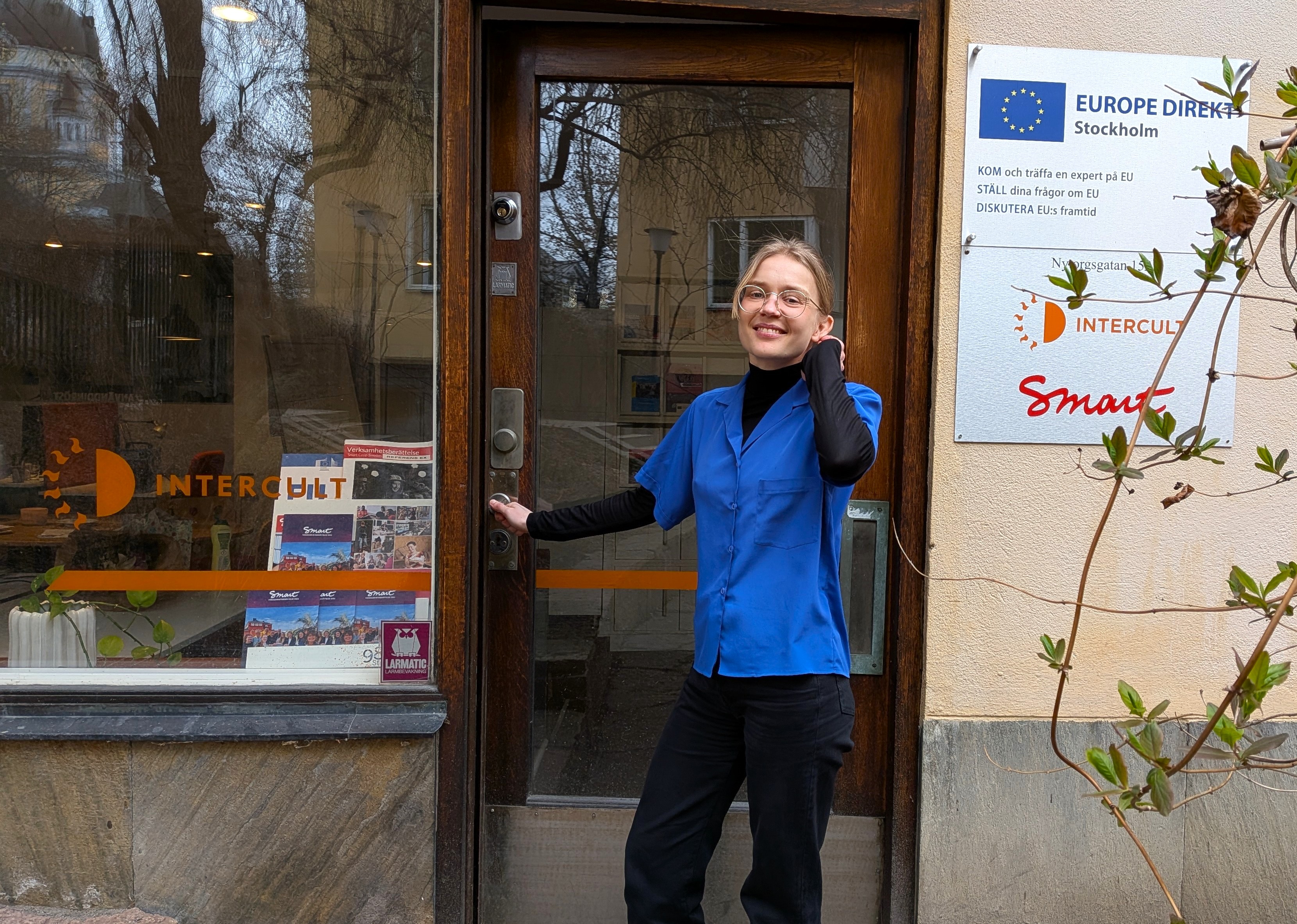 Karin Johansson, tidigare TÖI-student och numera projektledare på Europa Direkt/Intercult, framför dörren till Europa Direkts kontor