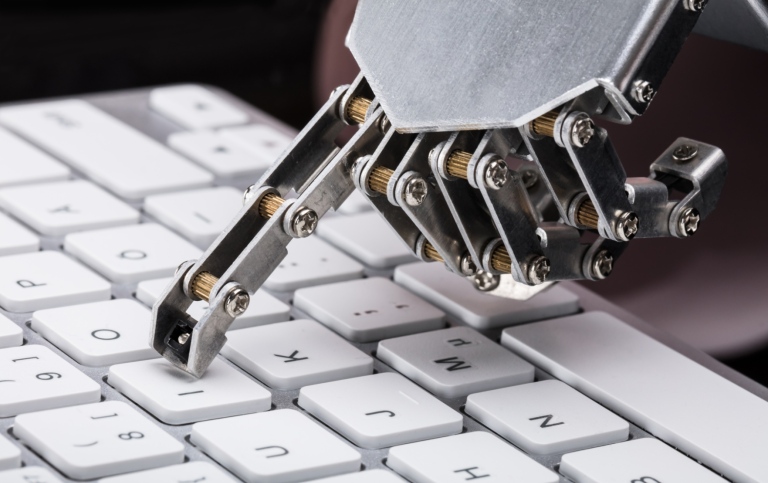 Robothand skriver på tangentbod.