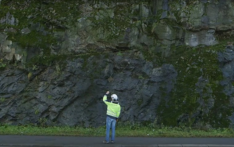 geologist looking at rock wall