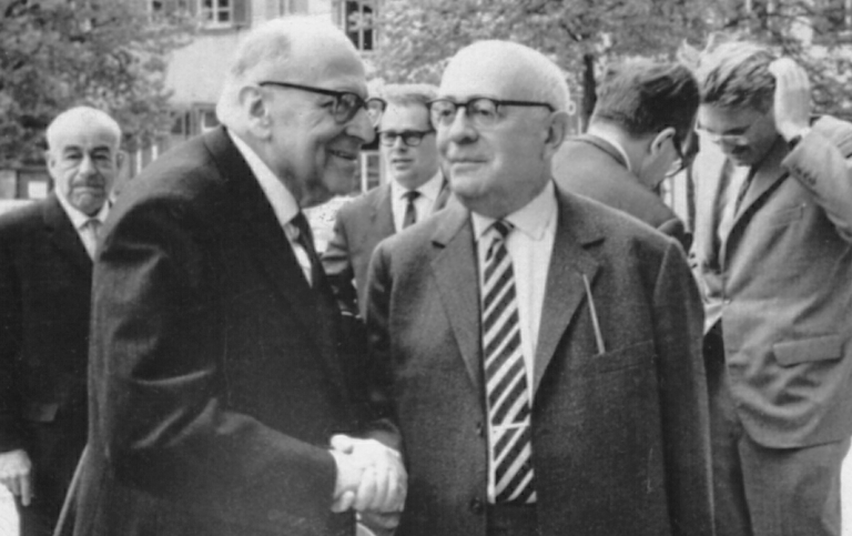 Svartvitt foto från 1964. Max Horkheimer och Theodor W. Adorno skakar hand